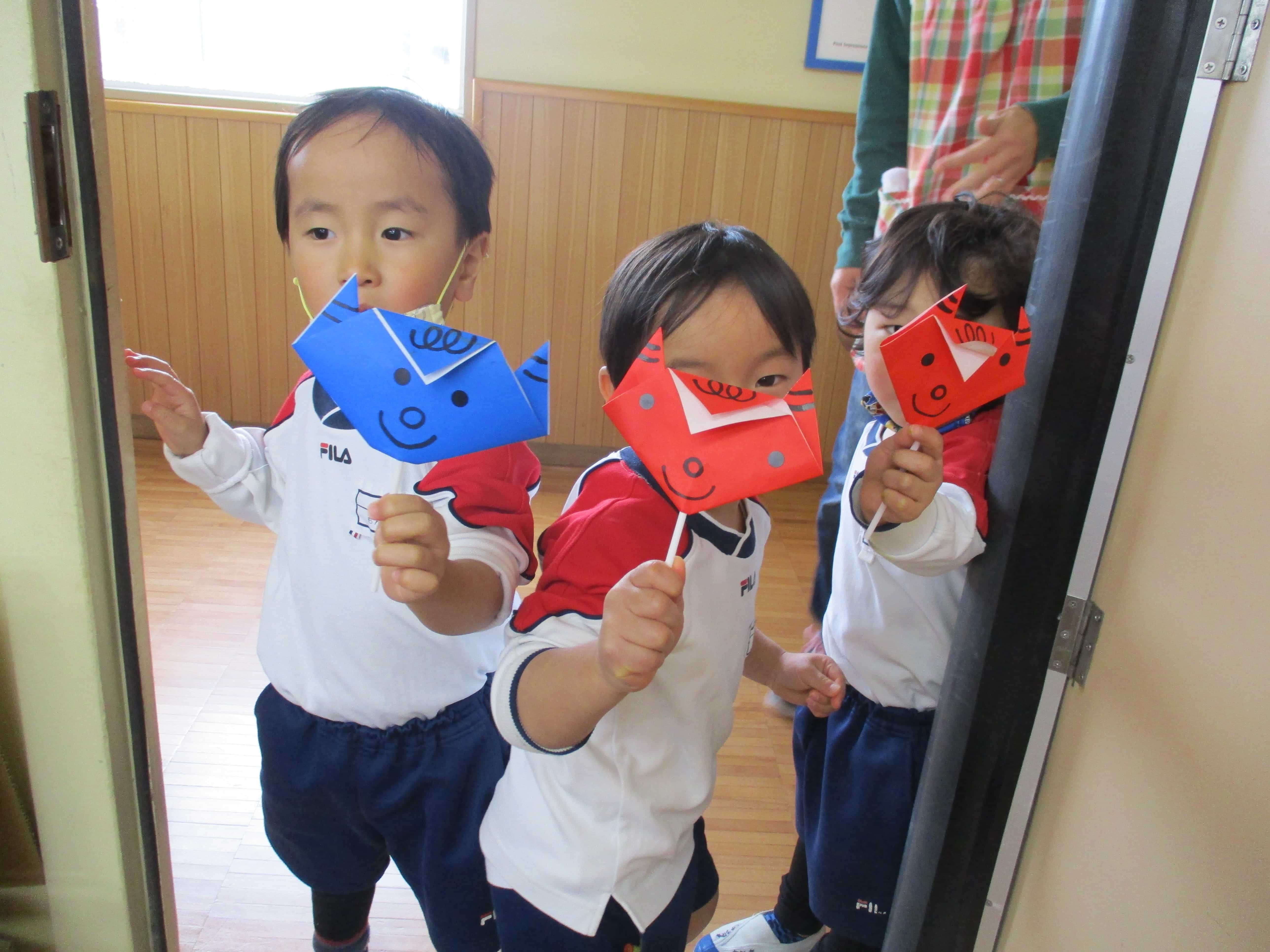 折り紙で遊ぶ園児たち